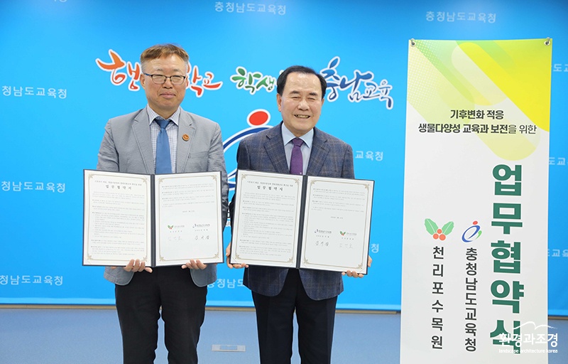 천리포수목원 원장과 충남교육청 교육감이 업무협약서를 들고 있다.jpg